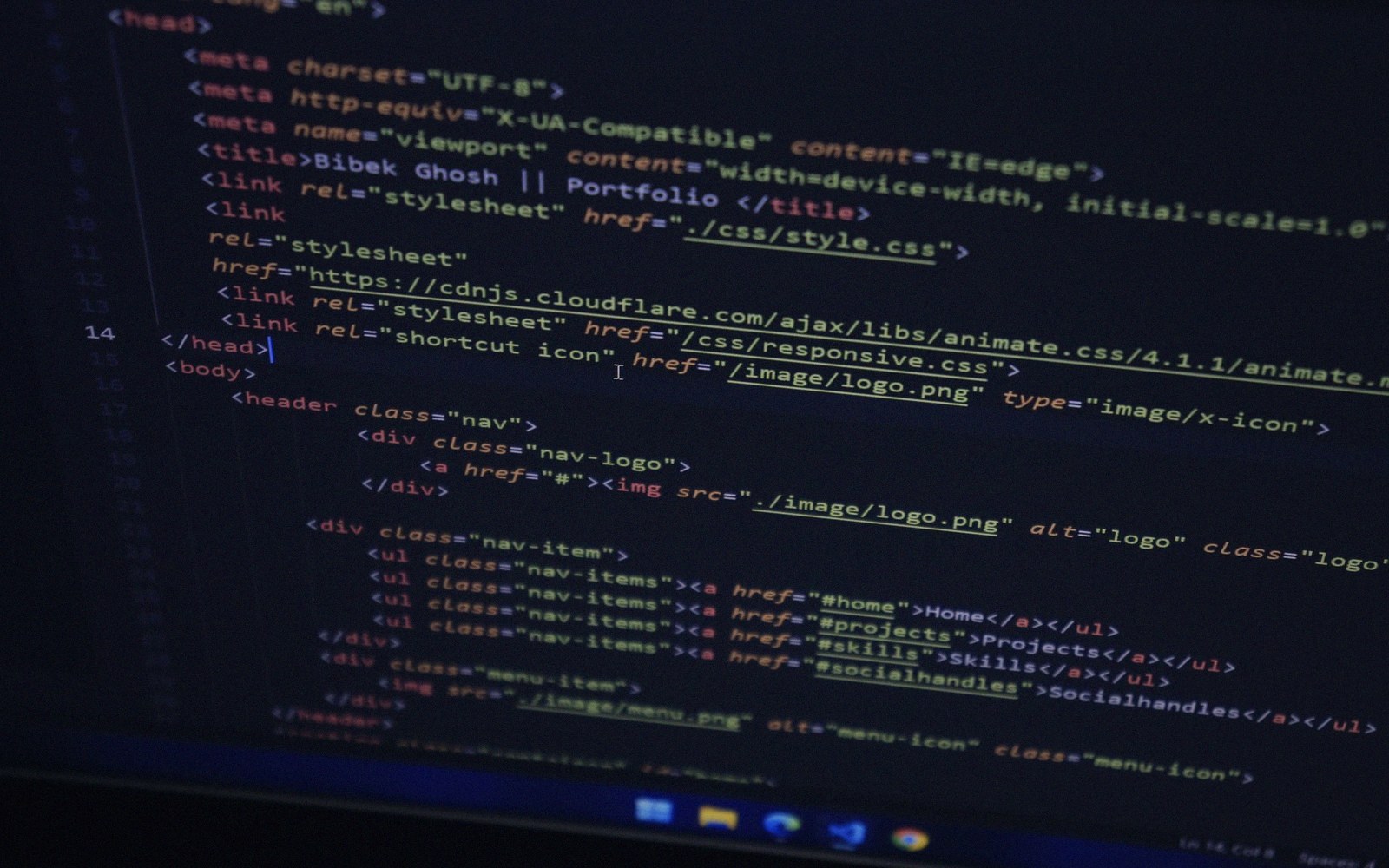 Computer screen displaying HTML code with syntax highlighting for a portfolio website